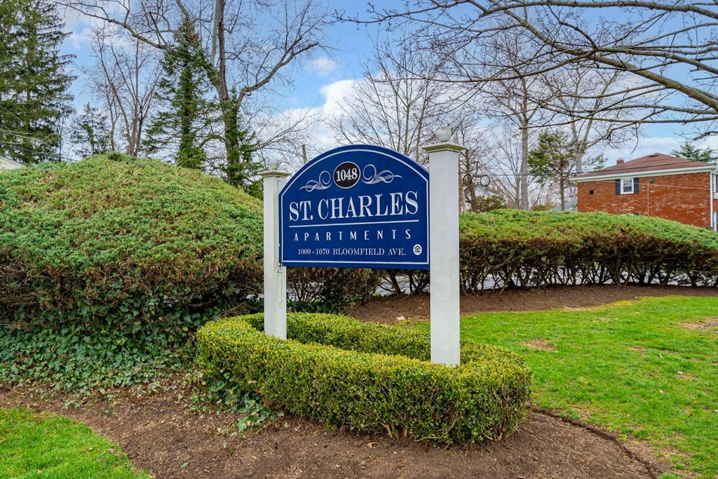 the sign apartments is in front of a manicured garden
