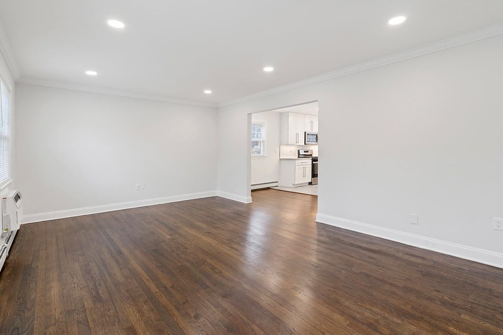 a living room with white walls and wood floors