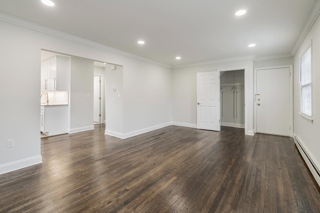 an empty living room with white walls and wood floors