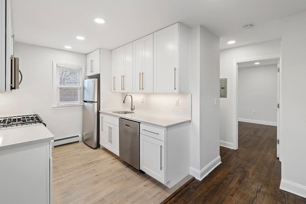 a kitchen with white cabinets and a stainless steel refrigerator