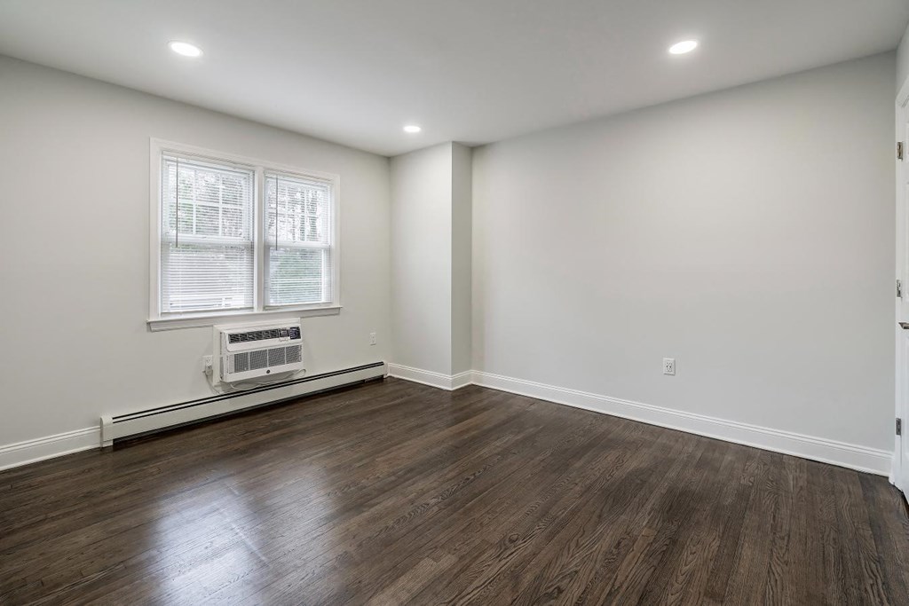 an empty living room with white walls and wood floors