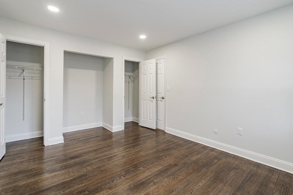 a living room with white walls and a closet with doors