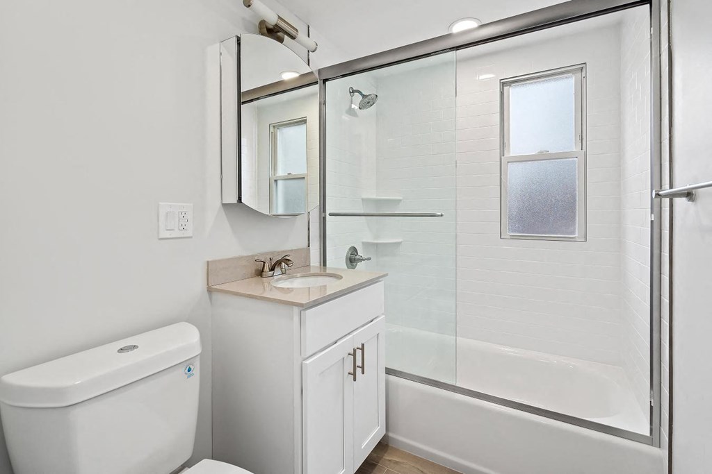 a white bathroom with a shower and a sink
