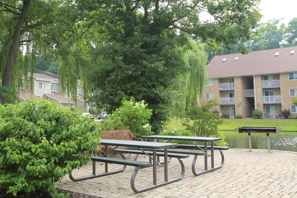 a group of picnic tables in a park next to an apartment building