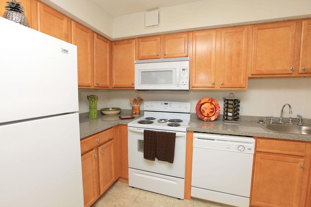 a kitchen with white appliances and wooden cabinets