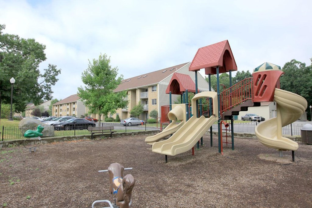 a playground with a slide in front of an apartment building