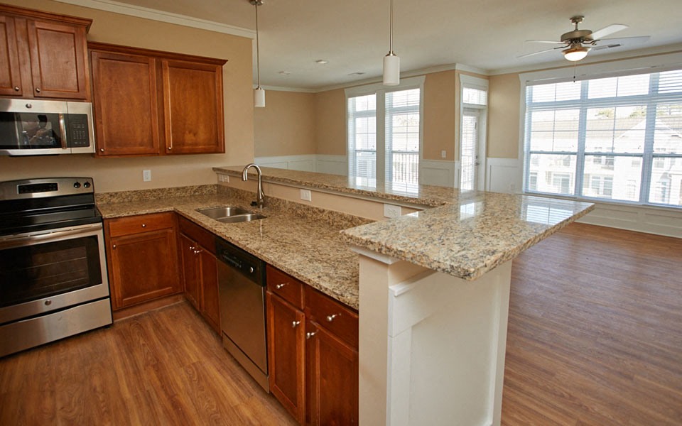 a kitchen with granite counter tops and wooden cabinets