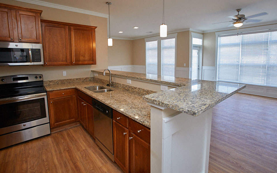 a kitchen with granite counter tops and wooden cabinets