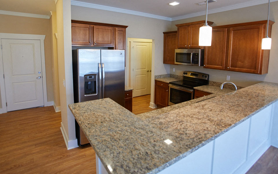 a kitchen with granite counter tops and a stainless steel refrigerator