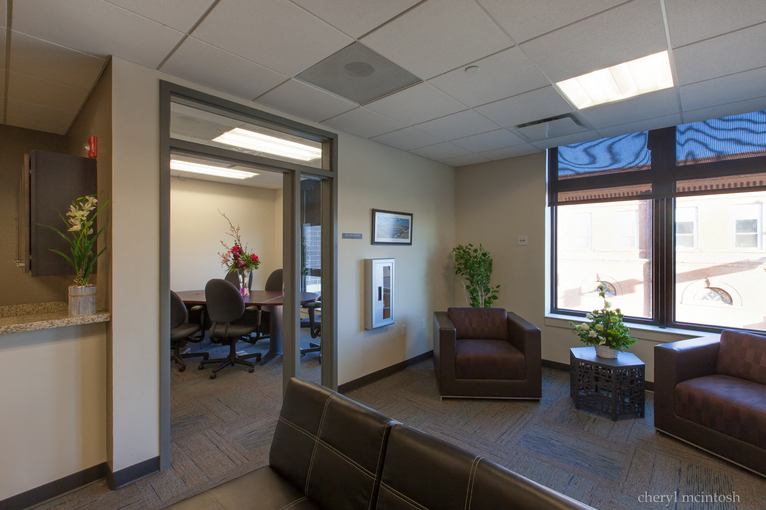 a lobby with couches and chairs and a table with plants