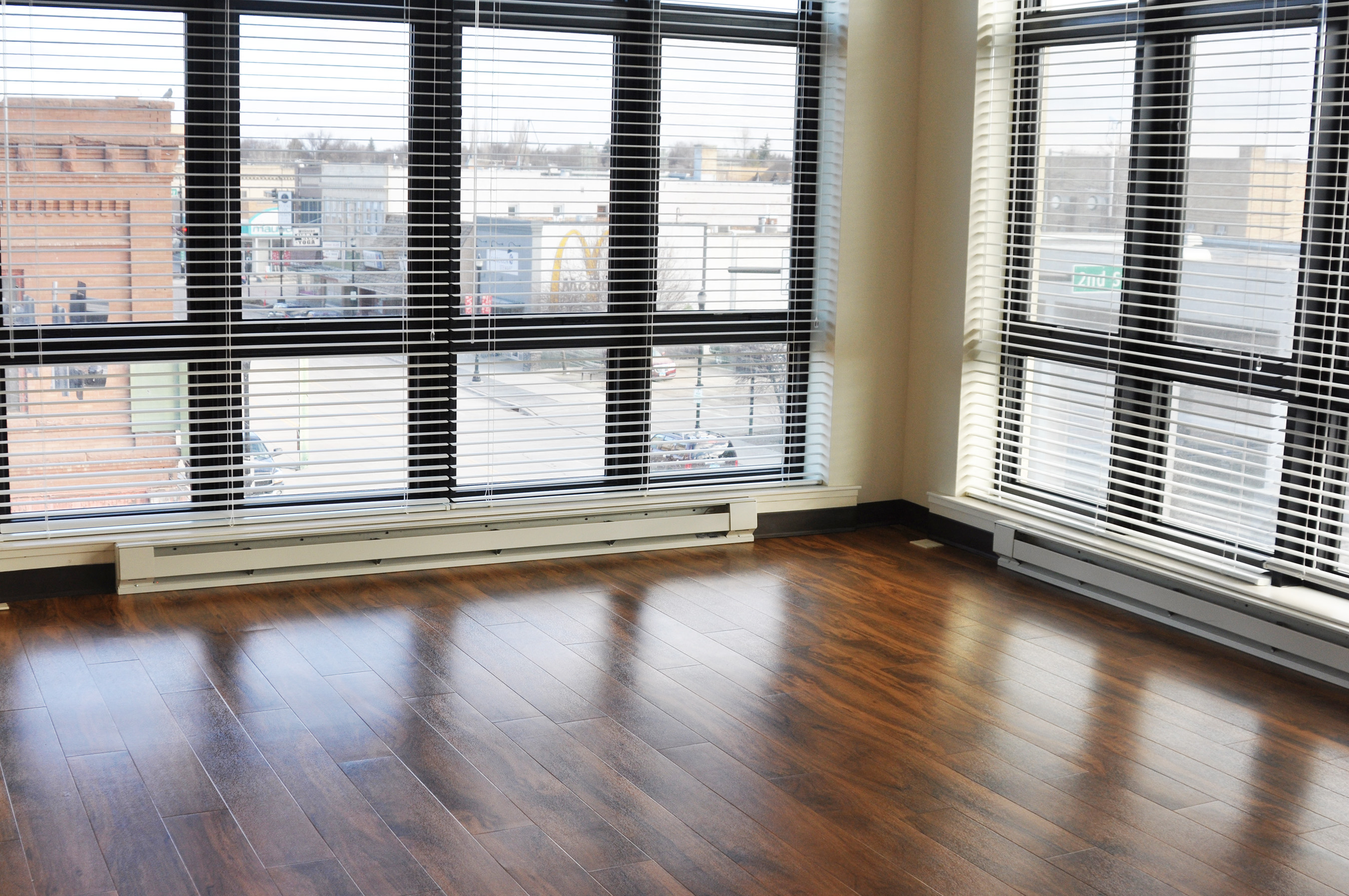 an empty living room with wood floors and windows