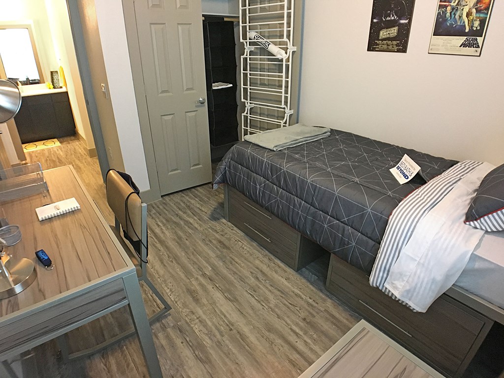 a small room with a bed and a desk and a closet