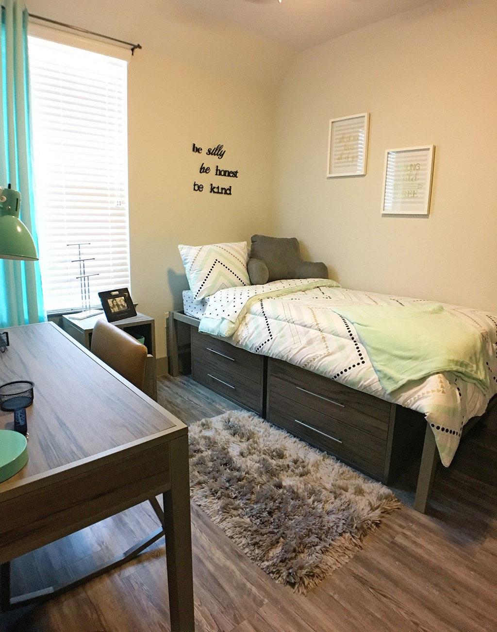 a bedroom with a bed and a desk and a window