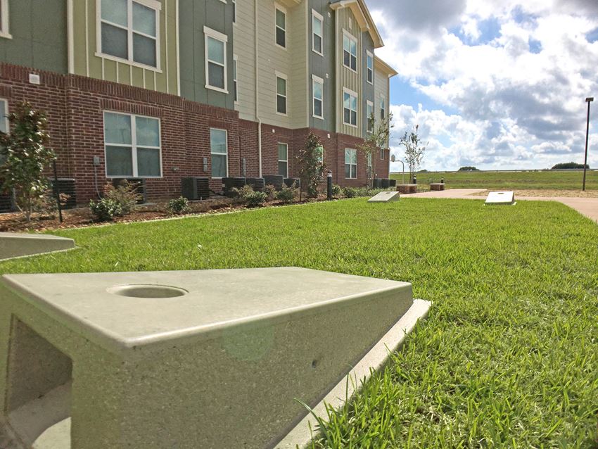 an apartment building with a cement bench in the grass