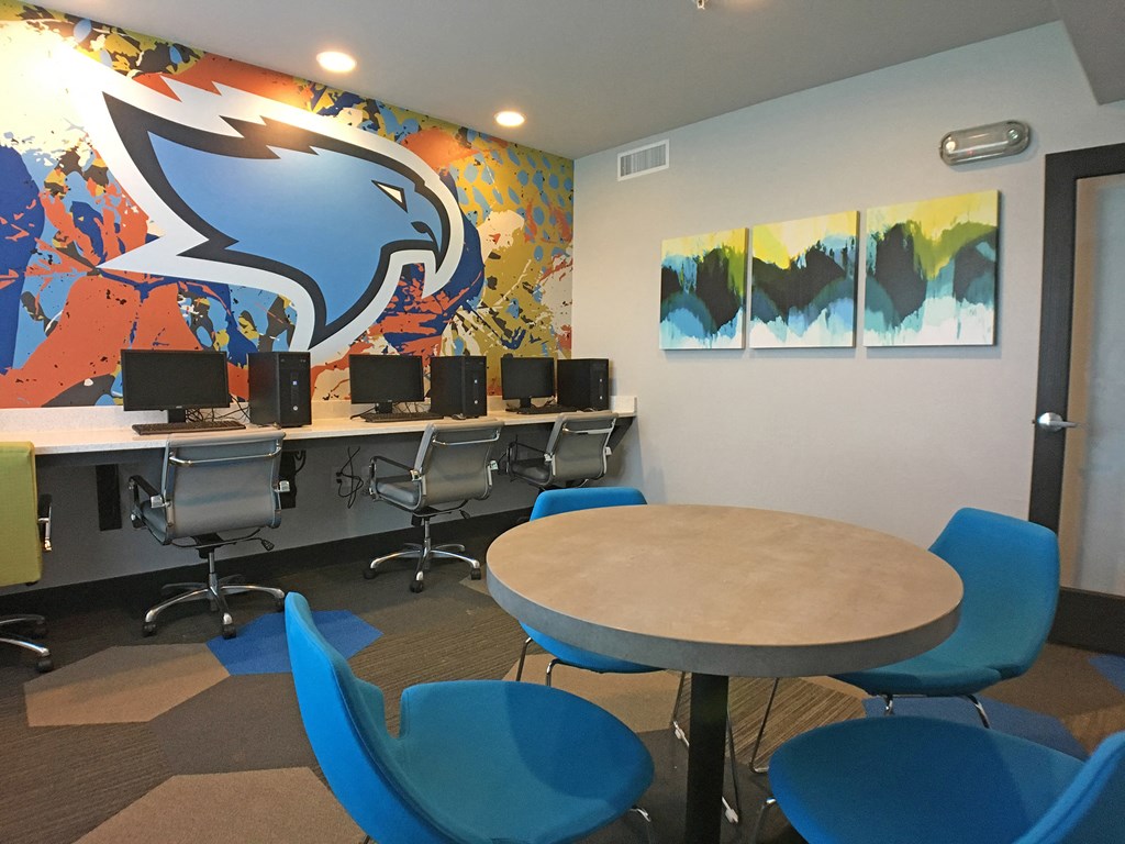a computer room with desks and chairs and a mural of a blue eagle