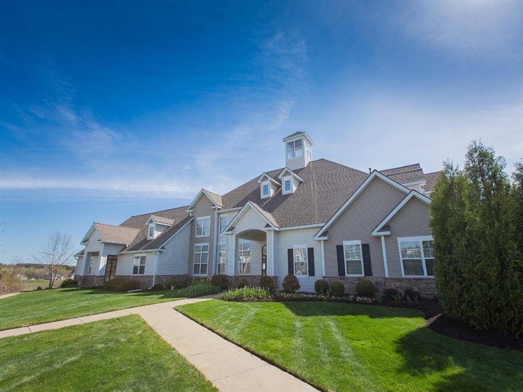 the front of a house with a sidewalk and lawn