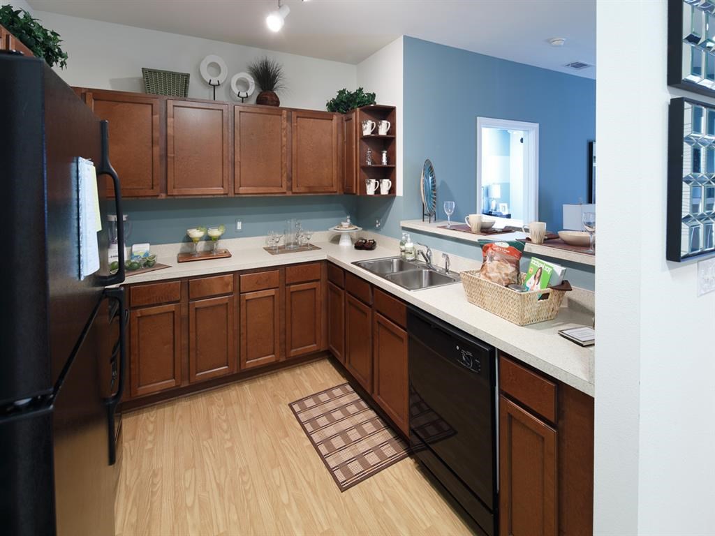 a kitchen with wooden cabinets and a black refrigerator