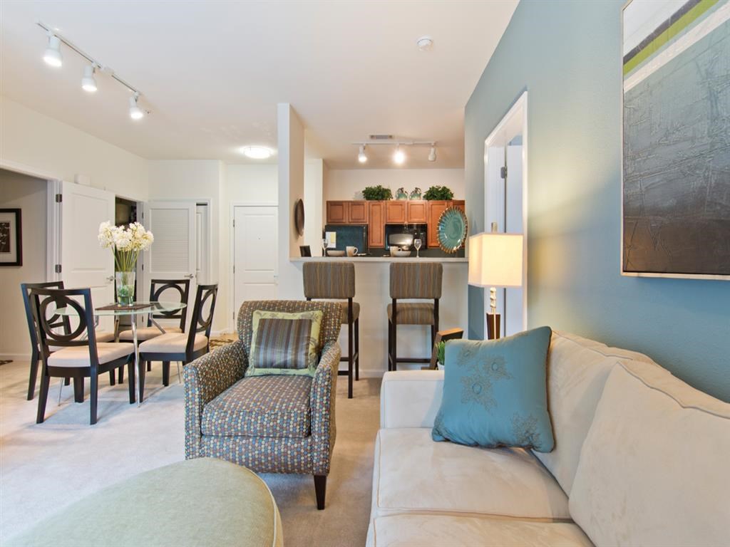 a living room and dining room with a couch and chairs