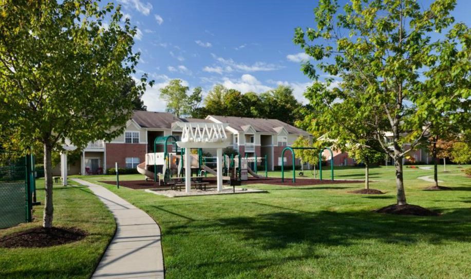 Community green lawn with trees and playground