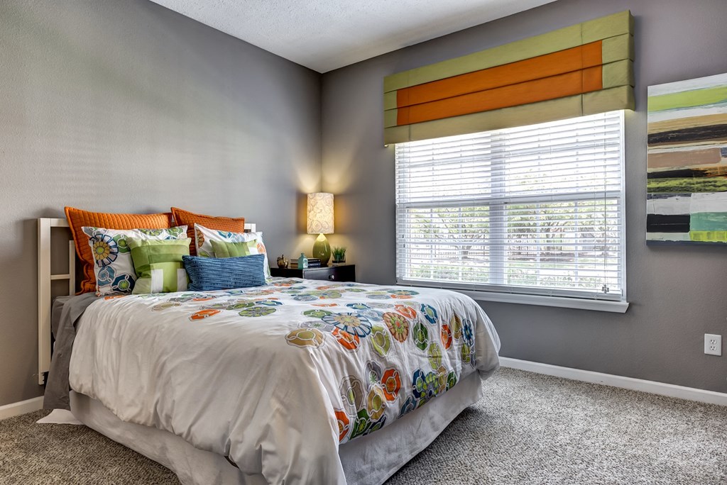 Upgraded guest bedroom with gray wall paint and carpet and large window