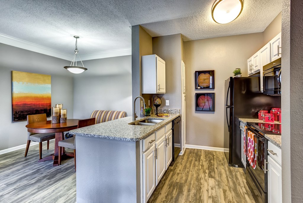 Upgraded Kitchen/Dining Upgraded model kitchen and dining room with granite countertops and black Whirlpool appliances