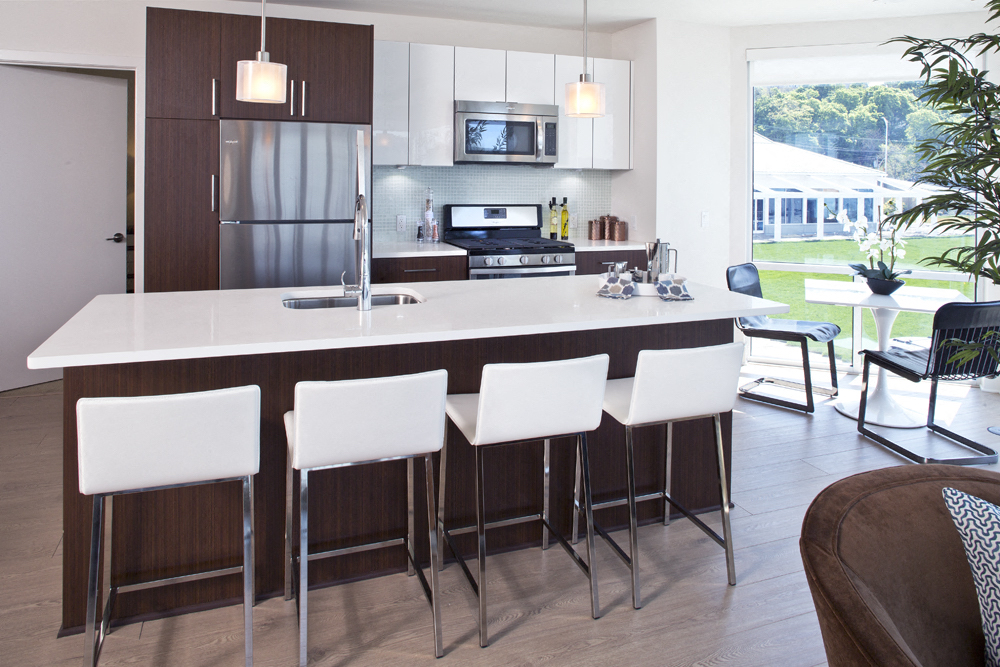 a modern kitchen with an island and white chairs
