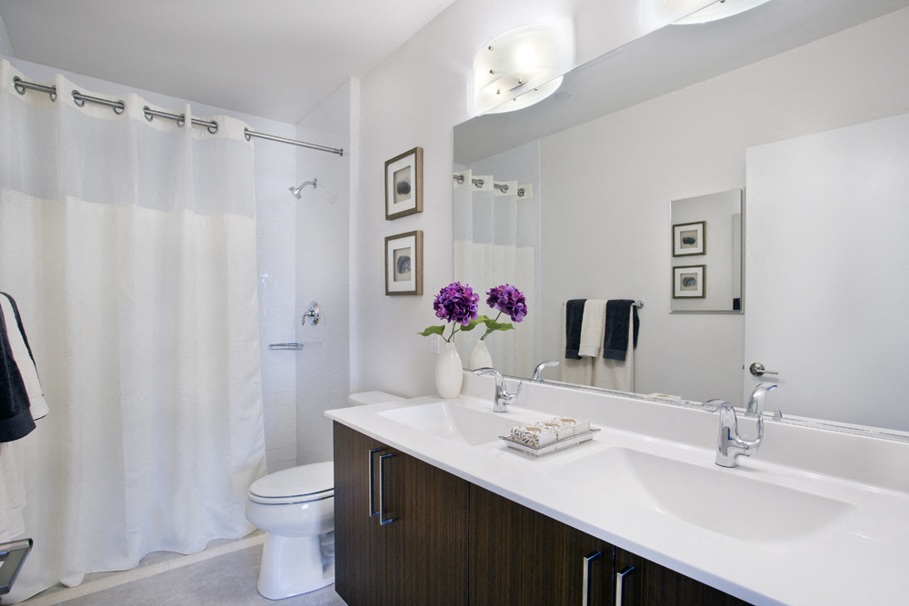 a bathroom with a large mirror and a sink and a toilet