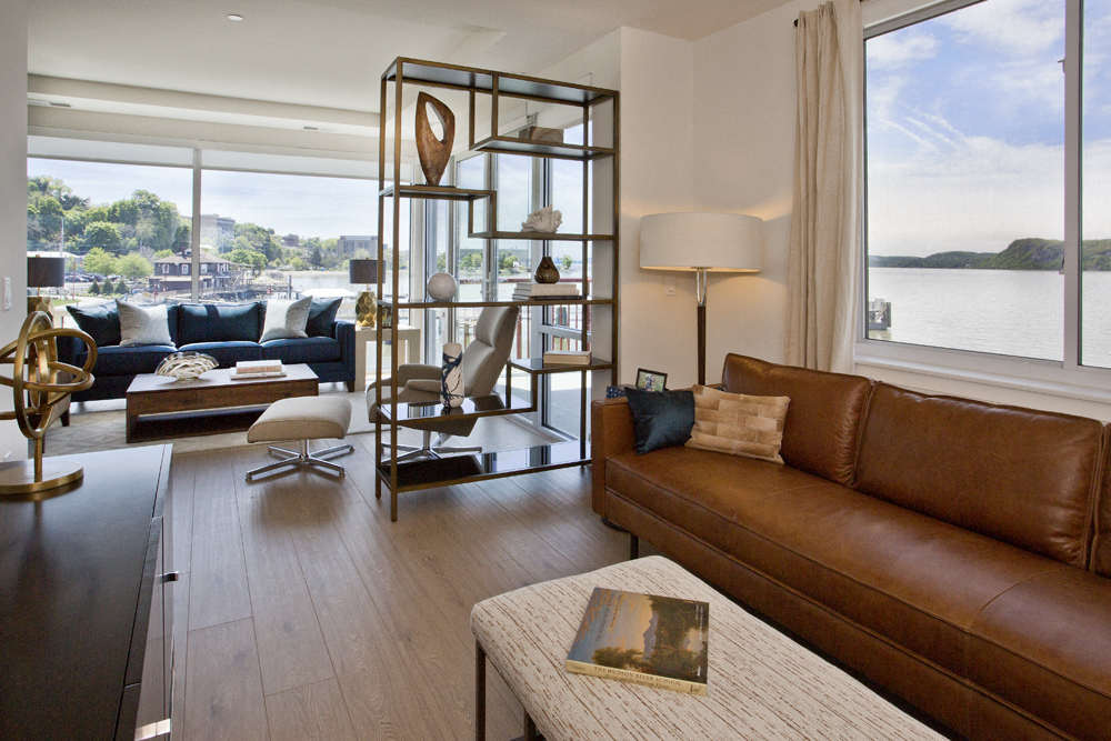 a living room with leather furniture and a view of the water