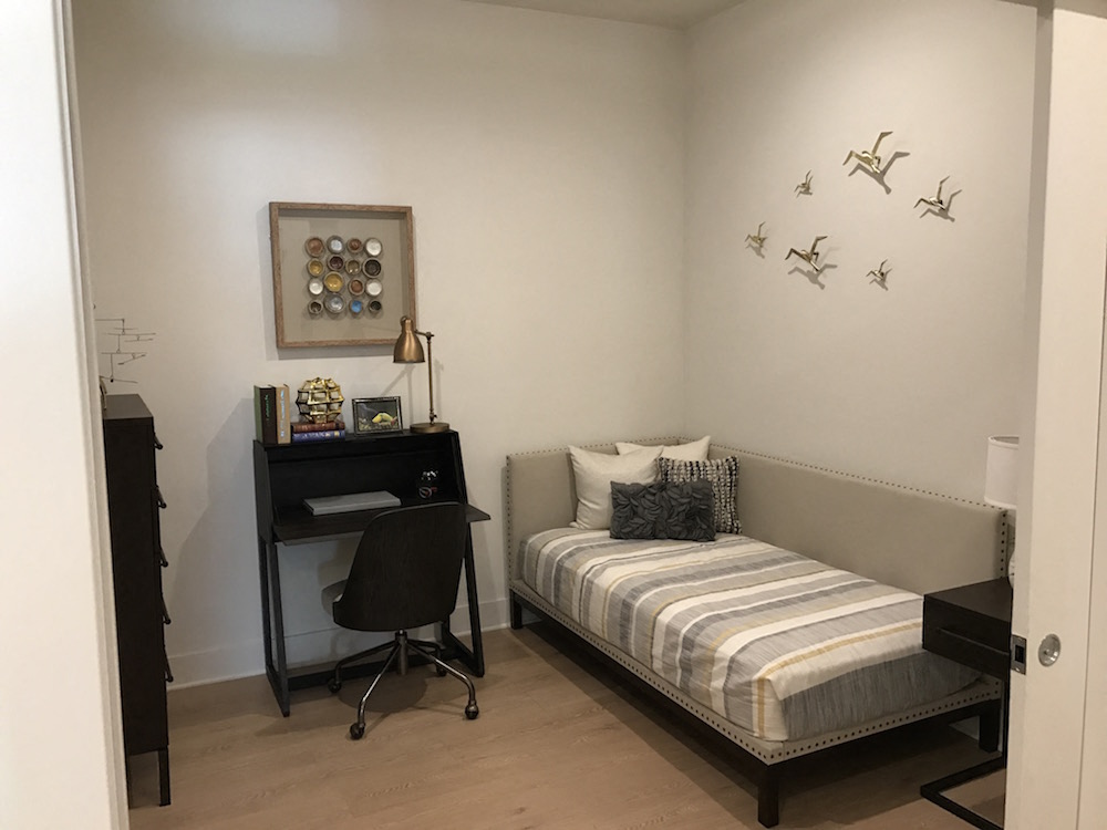 a small bedroom with a bed and a desk