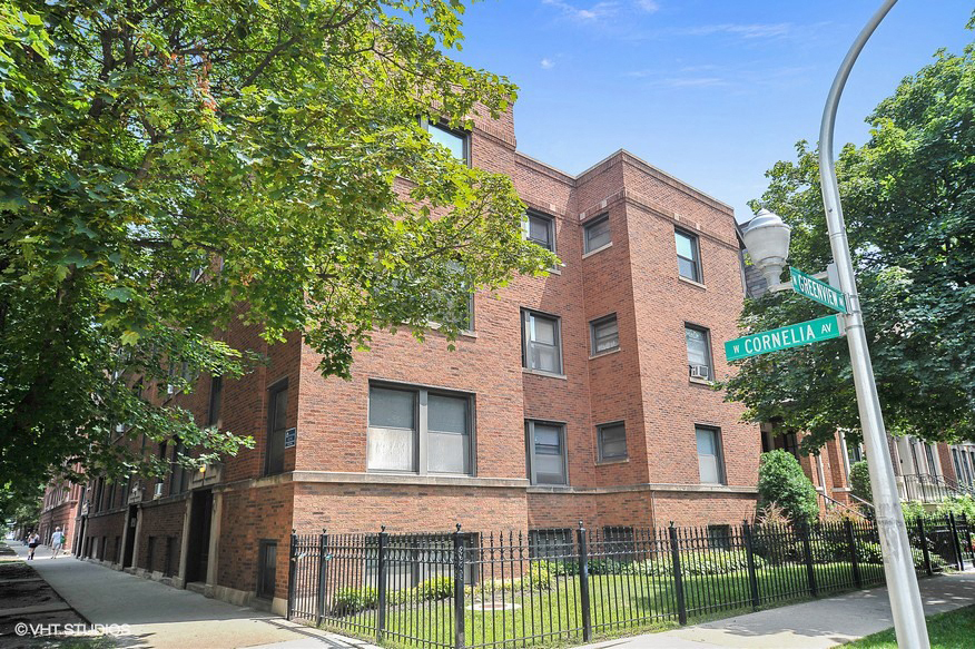 a brick building with a street sign in front of it