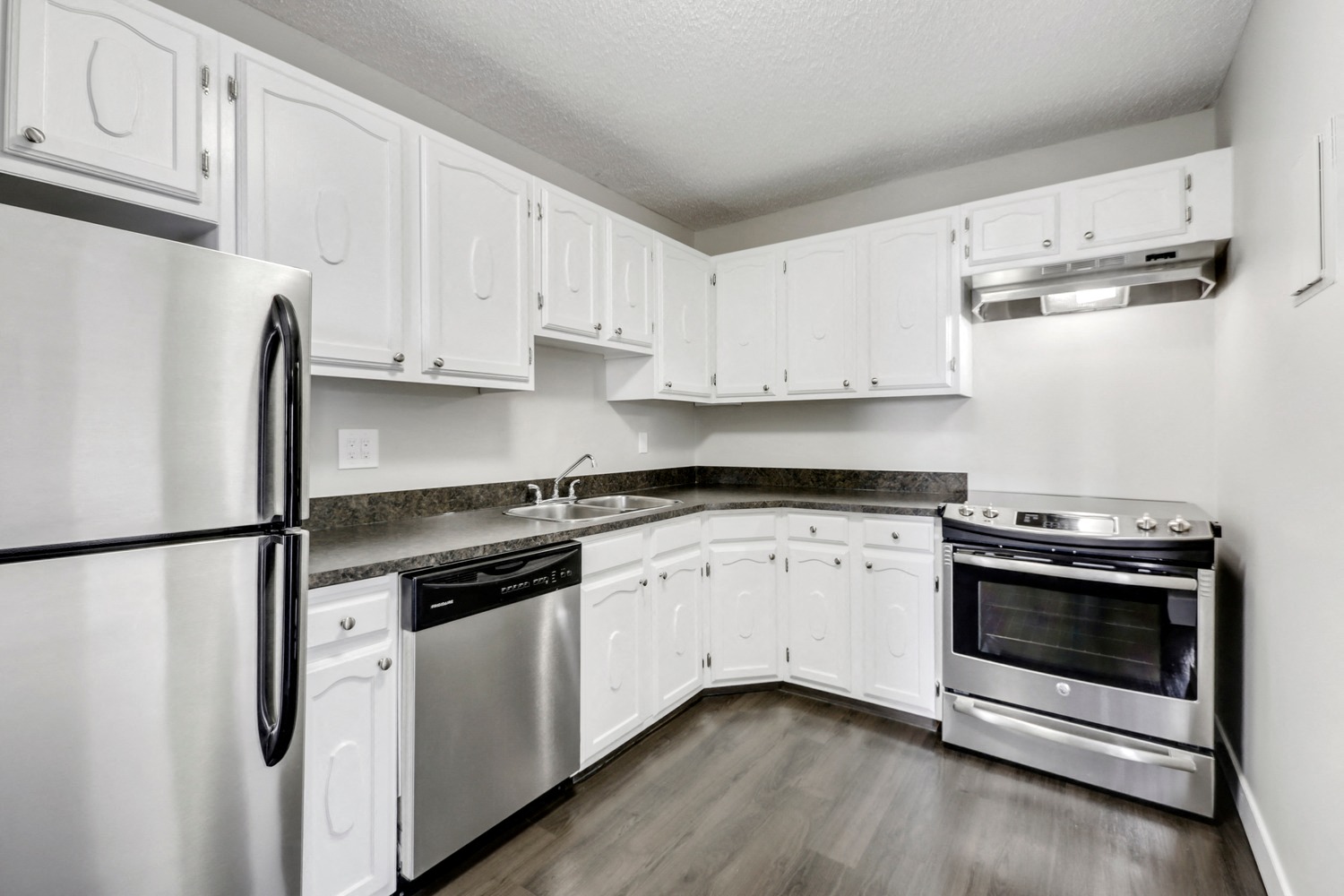 A kitchen with white cabinets and stainless steel appliances.
