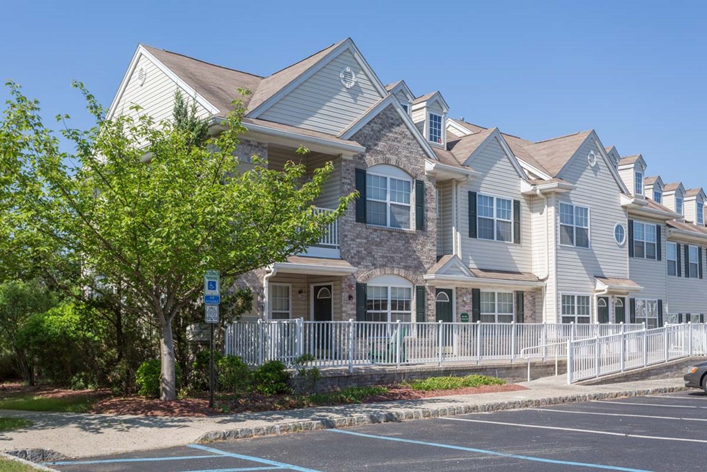 a large house with a tree in front of a parking lot