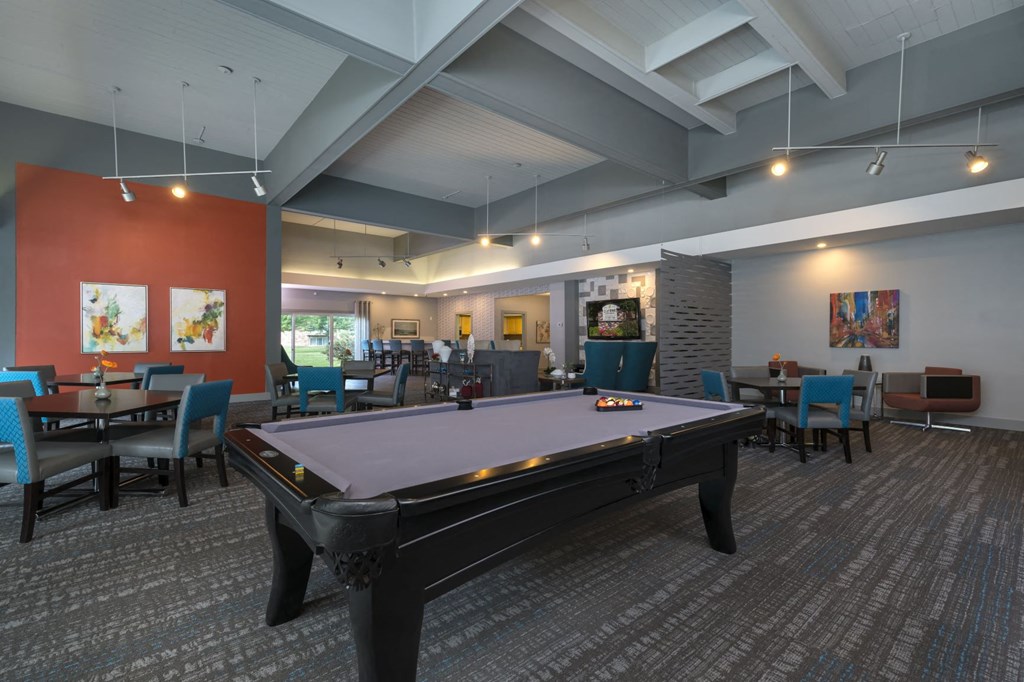 a pool table in a room with tables and chairs