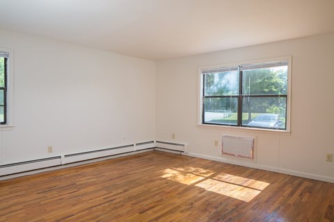 a living room with wood floors and a large window