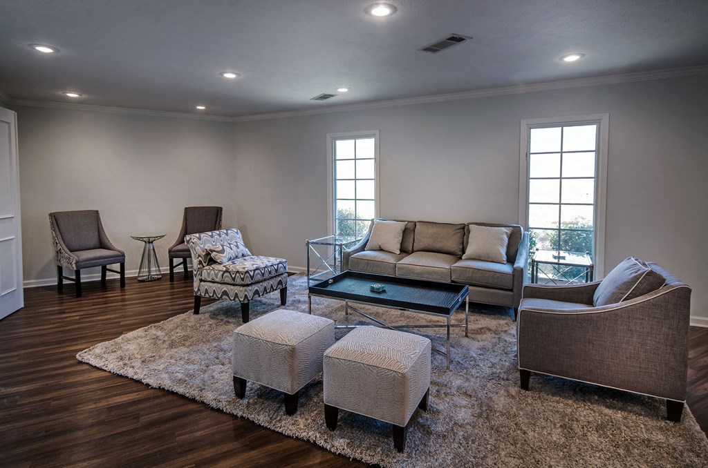 a living room with couches and chairs and a rug
