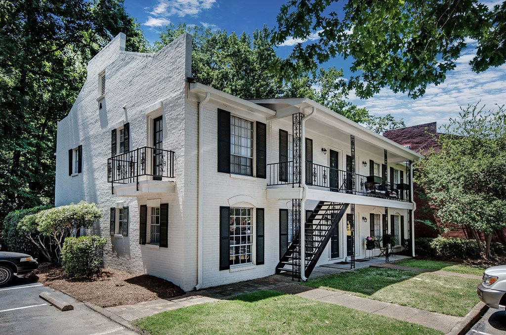 a white house with black windows and a black staircase