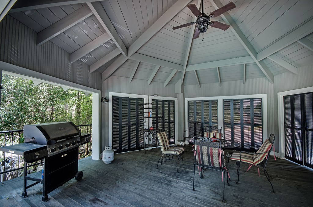 a screened in porch with a grill and a table and chairs