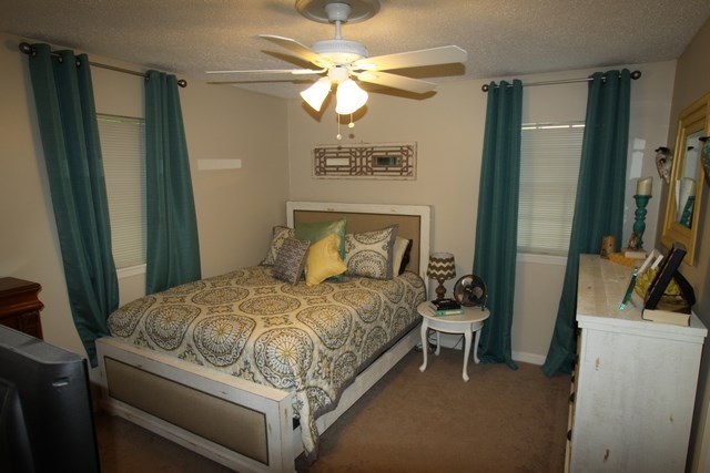 a bedroom with a bed and a ceiling fan