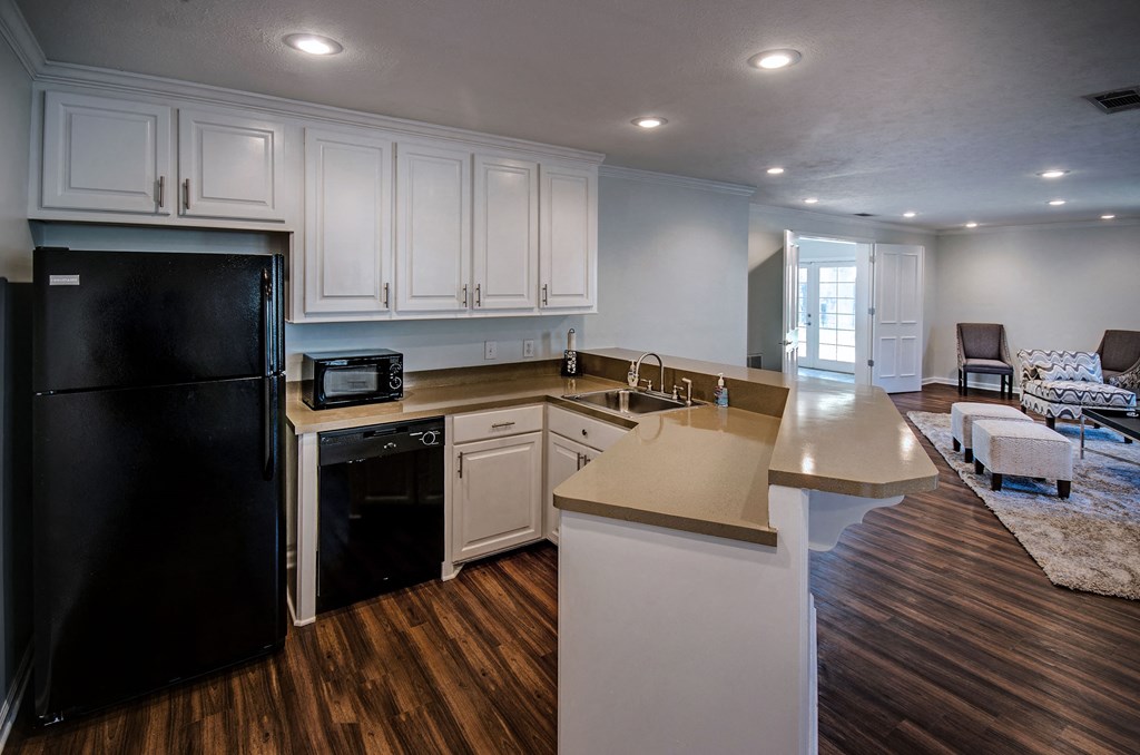 a kitchen with white cabinets and a black refrigerator