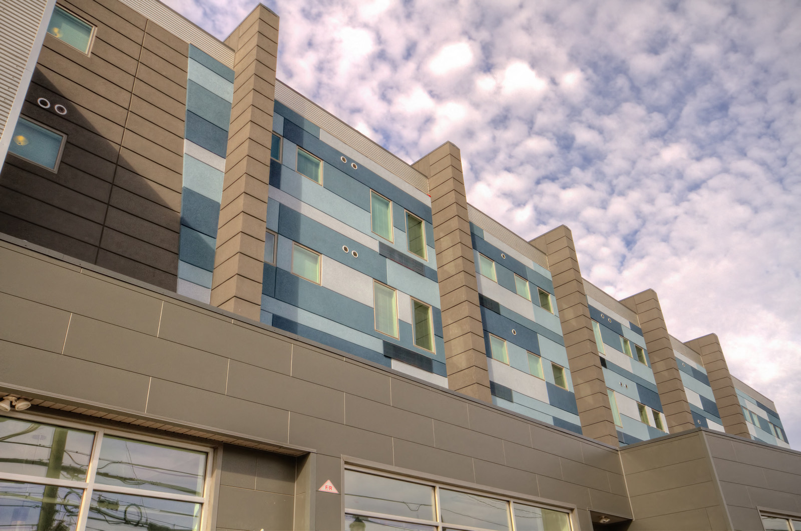 A modern building with a series of windows and a grey facade.