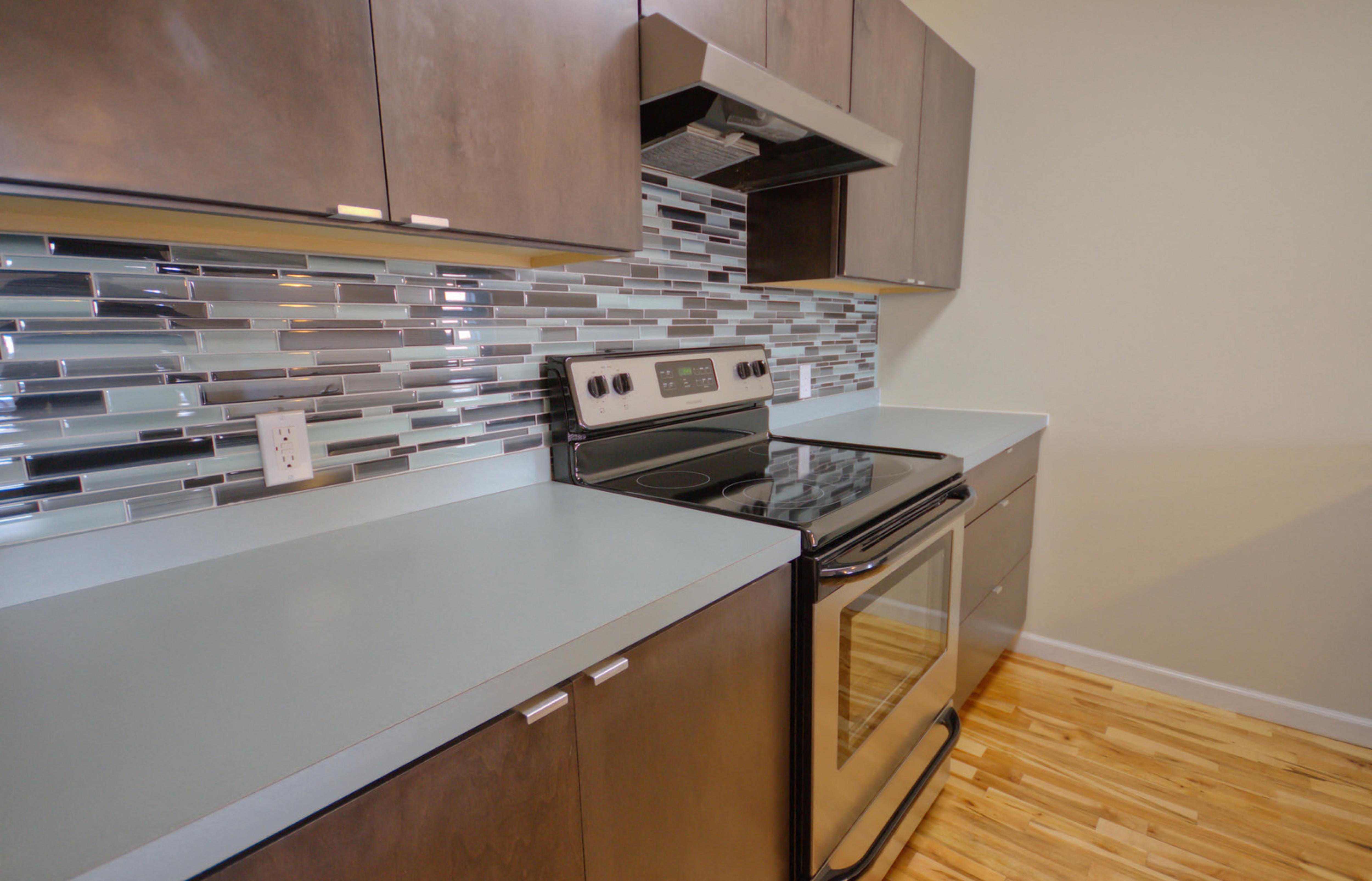 A modern kitchen with a stove and oven built into the counter.