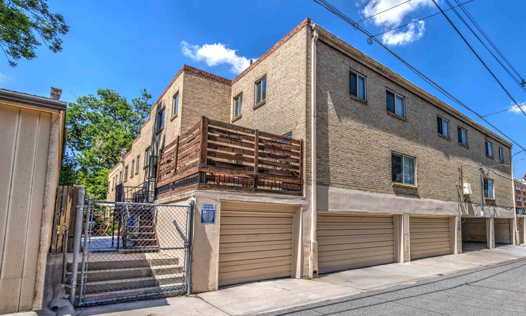 a large brick building with garages and a fence