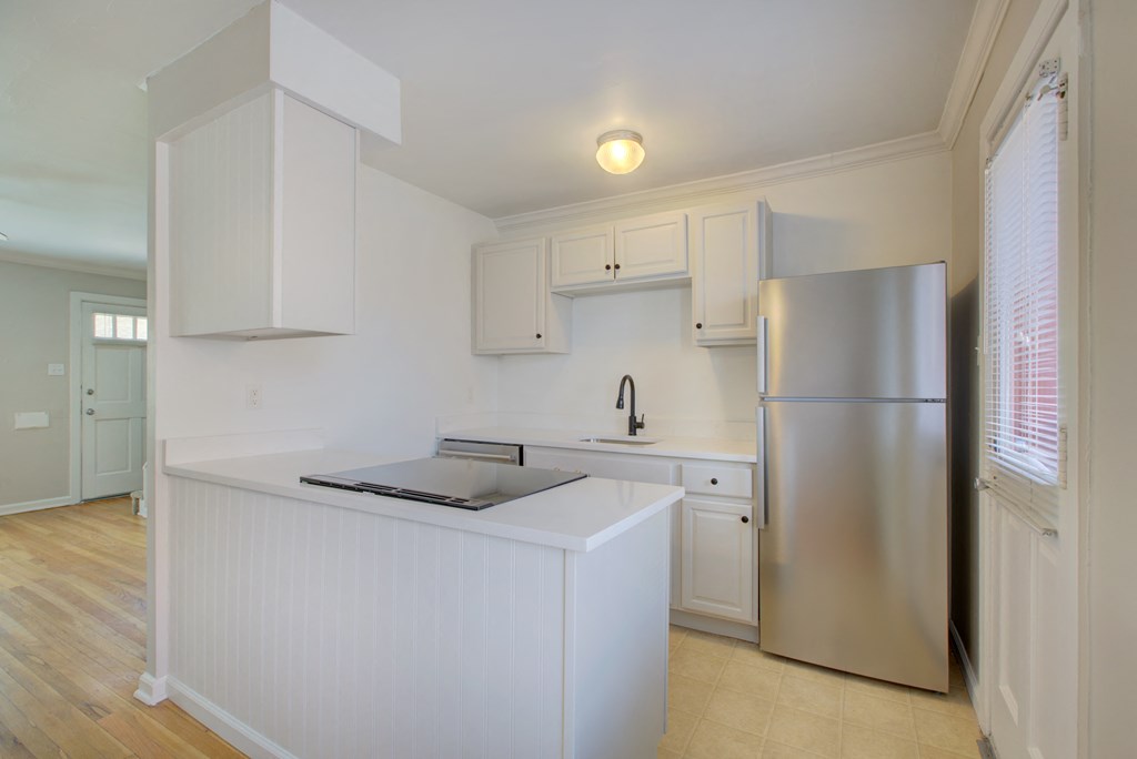 a kitchen with white cabinets and a stainless steel refrigerator
