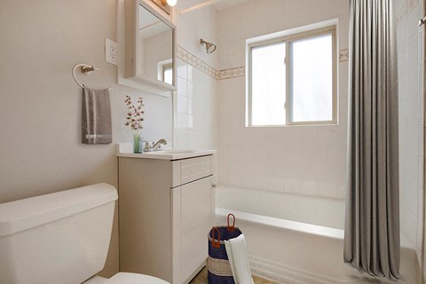 a white bathroom with a shower and a sink