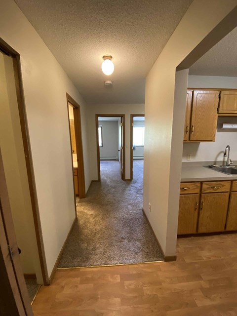 a kitchen and a hallway with a sink and a mirror