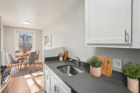 A kitchen with a table and chairs in front of a window.