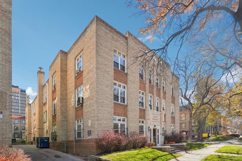 A large brick building with a tree in front of it.
