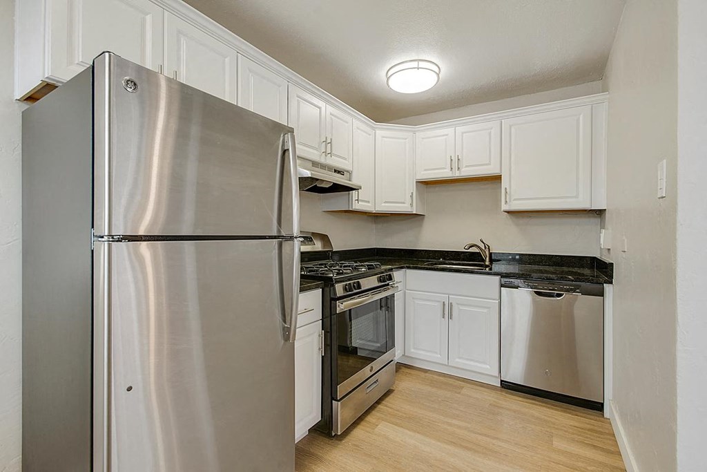 a kitchen with stainless steel appliances and white cabinets