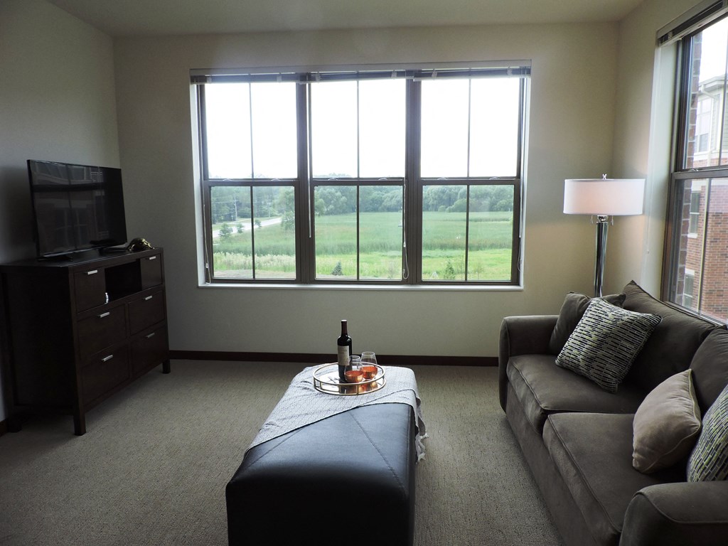 a living room with a couch and a table with a bottle of wine