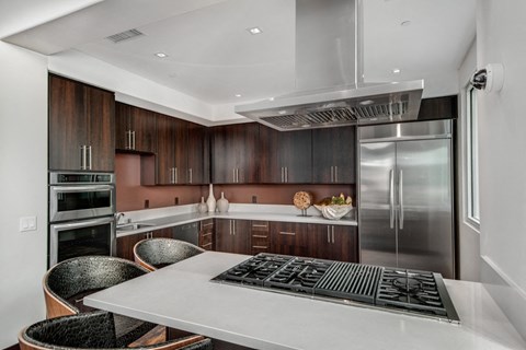 A modern kitchen with a stainless steel refrigerator and wooden cabinets.